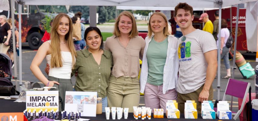 A group of students volunteering at an outdoor health awareness event.