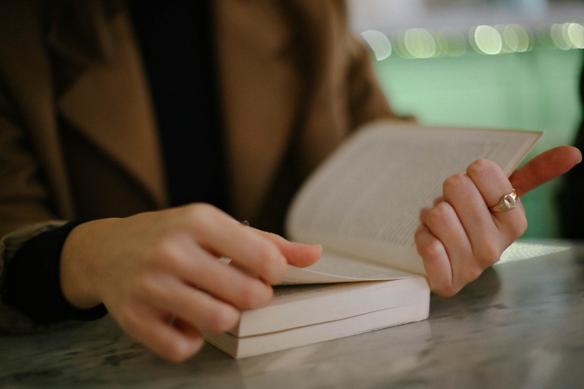 person flipping pages in a book