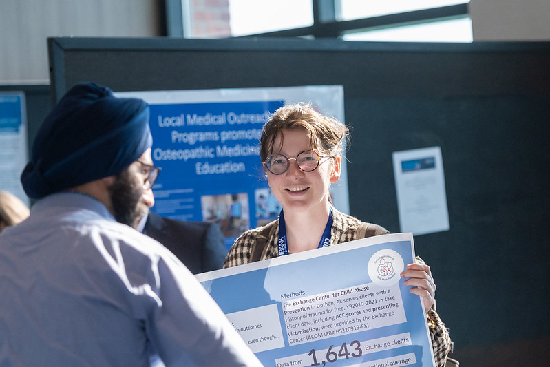 Poster exhibitor discussing her research.