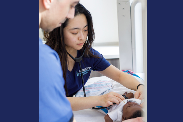 KansasCOM student using stethoscope to hear a baby's heart rate