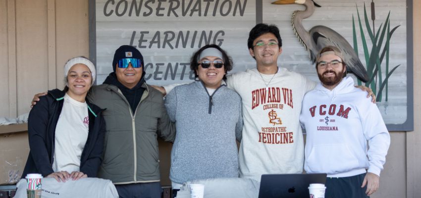 VCOM-Louisiana students take a moment to pause for a photo while working at the Bayou WAR 5K event.