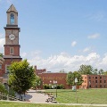 AscenicviewoftheWestVirginiaSchoolofOsteopathicMedicineWVSOMcampusfeaturingaclocktoweracademicbuildingsandalargegreenlawnunderabluesky