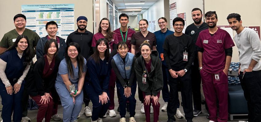 A group of student pose in the hallway of a research lab.