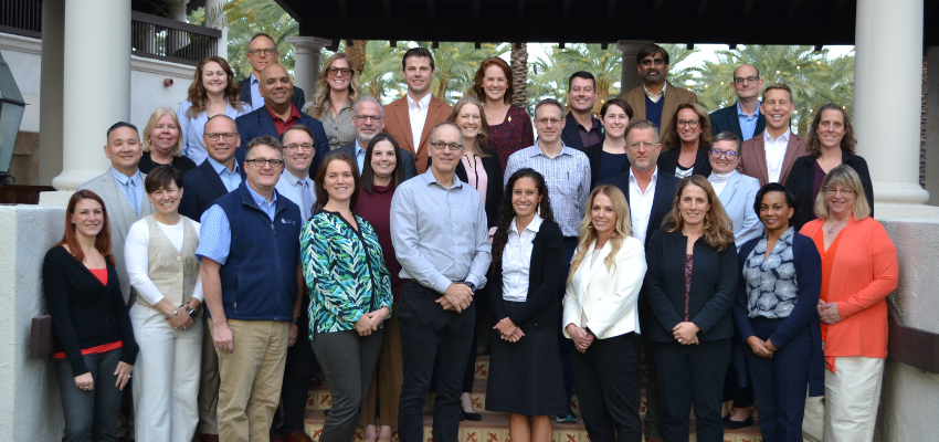 The 2024-2025 class of AACOM's senior leadership development program stand outside for a group photo.