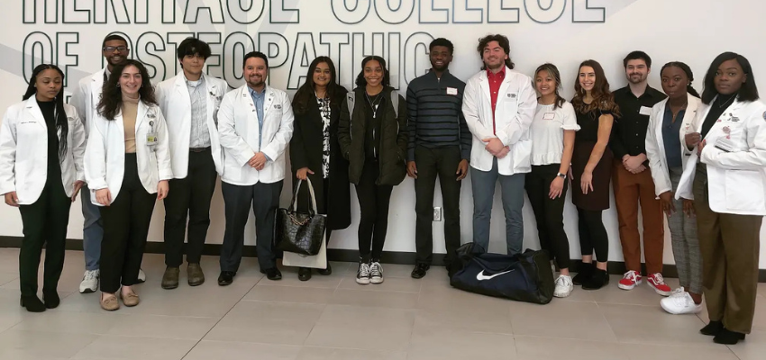 Medical students and high school students standing in OU-HCOM entrance