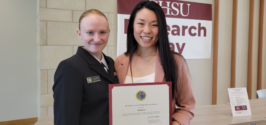 Christine Su holds up her award certificate