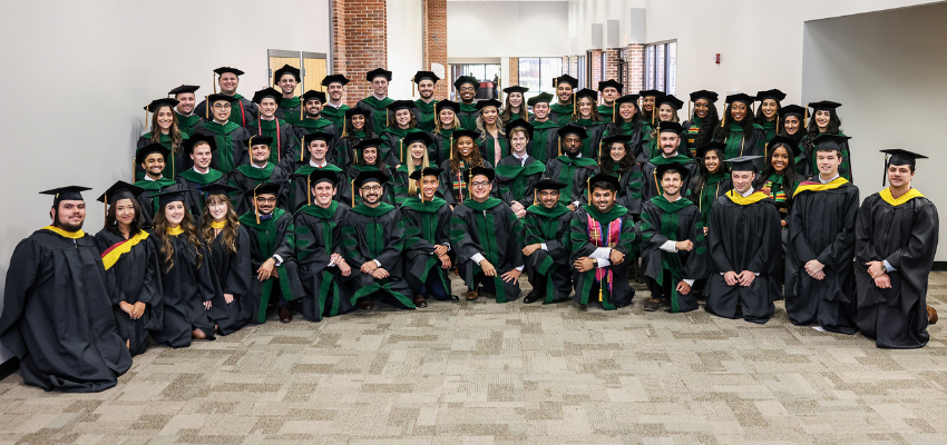 PCOM South Georgia class in four rows with graduate cap and gowns.