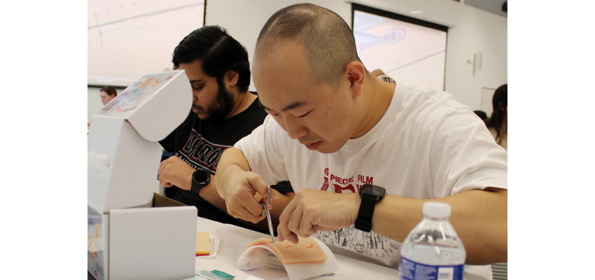 Medical student practices suturing