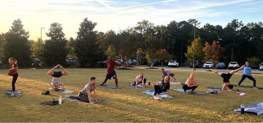 Students performing a multitude of yoga poses on the school lawn