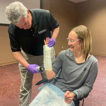 Professor removing a student's arm cast