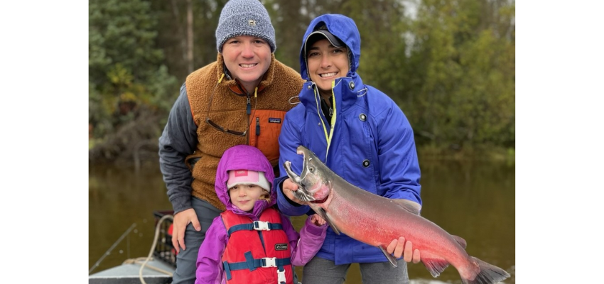 OSU-COM student holds salmon next to her husband and daughter