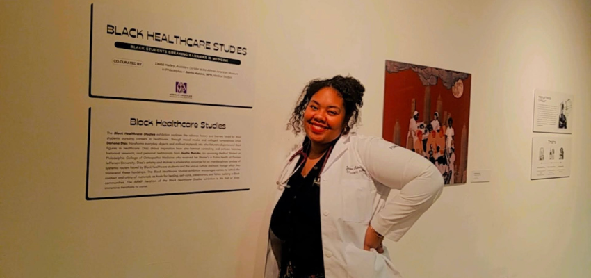 Janita Matoke in front of plaque for Black Healthcare Studies