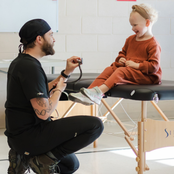 Student shows young girl a stethoscope