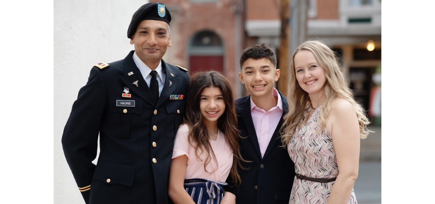 Medical student Hauns stands in military regalia with wife and two children