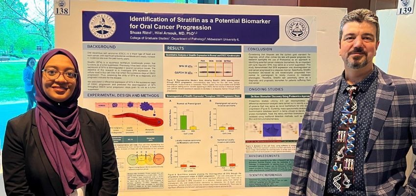 Two researchers presenting a scientific poster on cancer biomarkers at a conference.