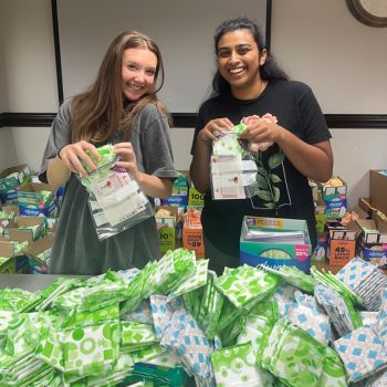 Two students preparing hygiene kits in a community service event.
