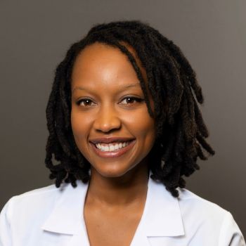 A portrait of a smiling medical professional in a white coat.